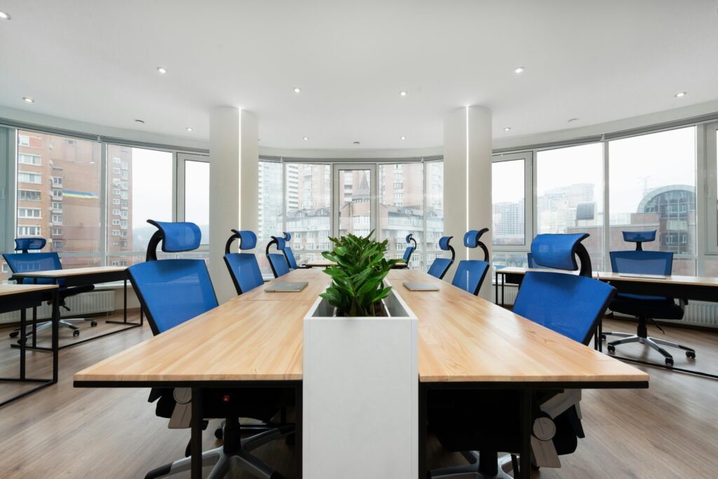 Spacious conference room with blue office chairs and natural light.